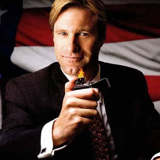 photo of Aaron Eckhart wearing a suit and holding out a lighter