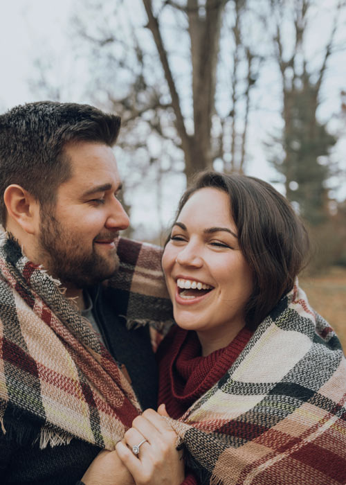 couple wrapped up in a blanket laughing